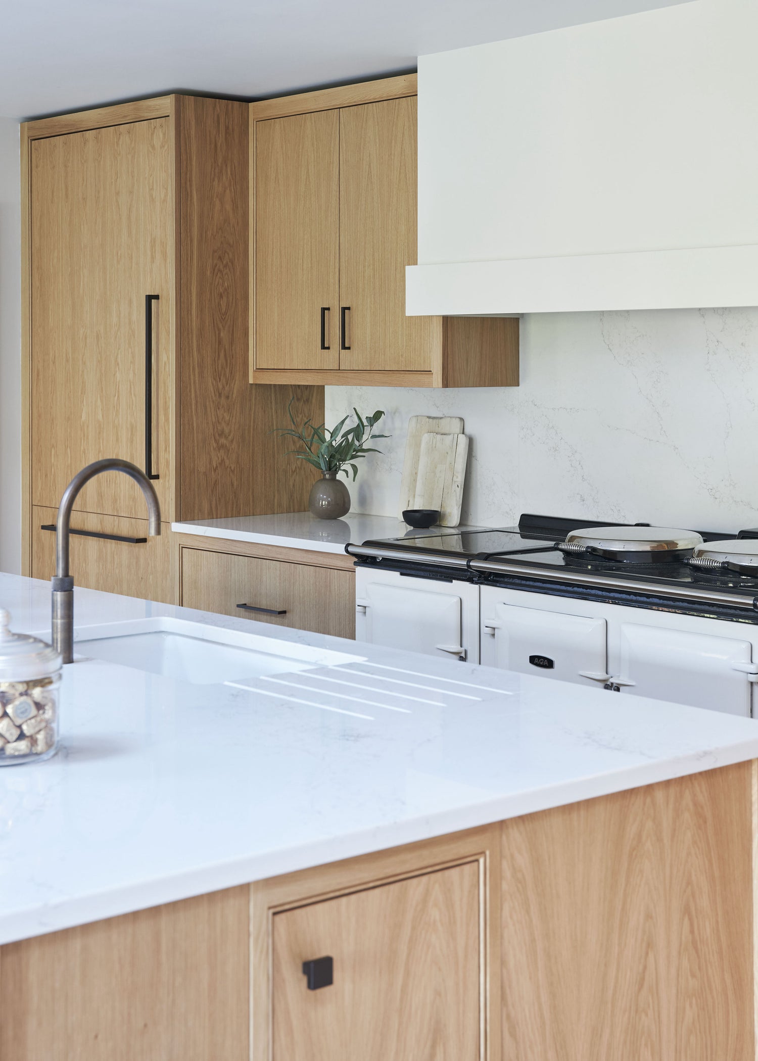 Bespoke kitchen with white quartz countertops, oak cabinetry, and integrated appliances
London kitchen design, quartz worktops, modern oak cabinetry, luxury British kitchen