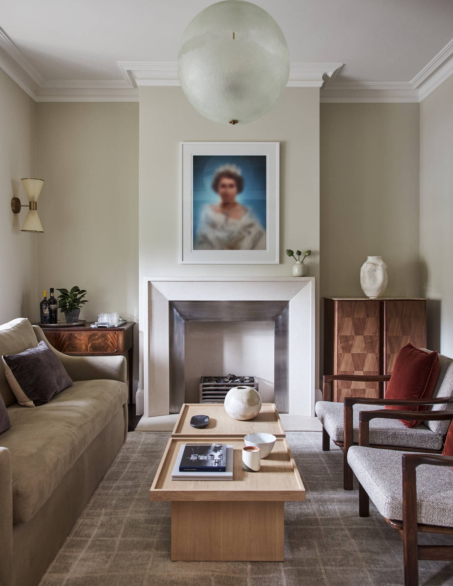 Modern living room with fireplace, portrait artwork, and wood coffee table in neutral tones