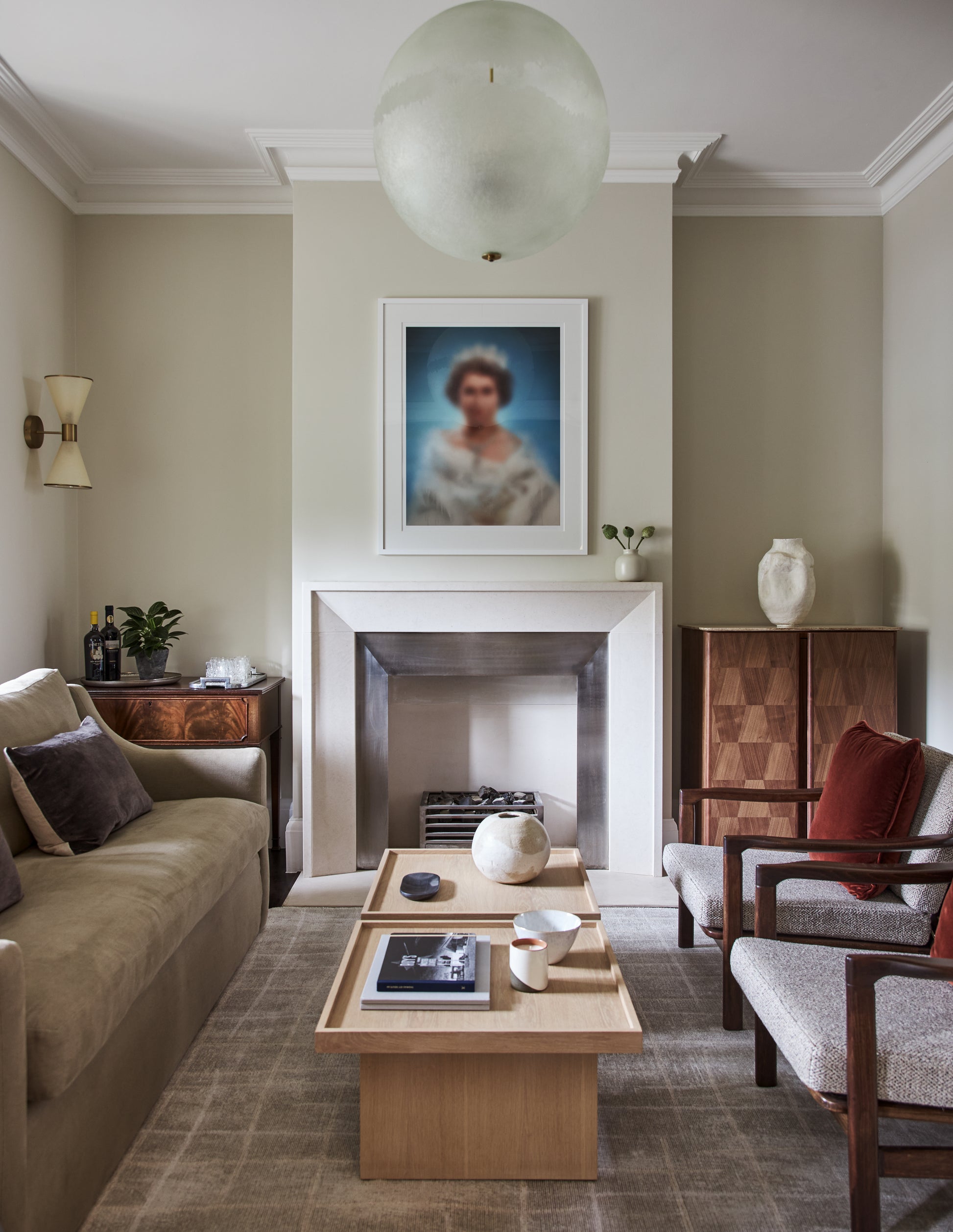 Modern living room with fireplace, portrait artwork, and wood coffee table in neutral tones