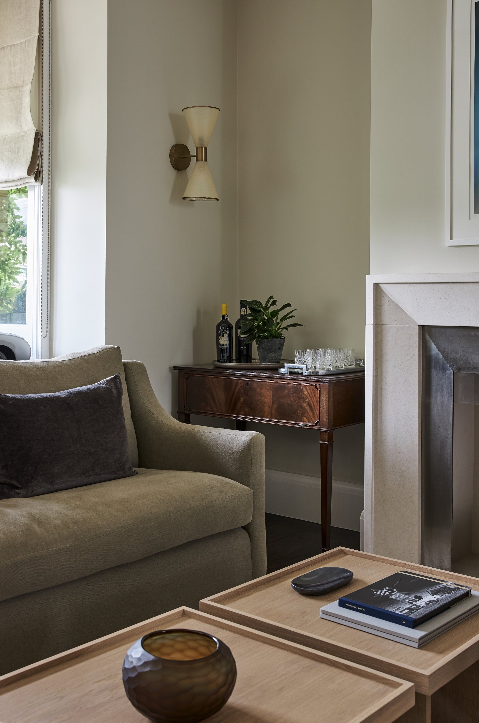 Sophisticated sitting area with olive green sofa and dark wood sideboard in contemporary space